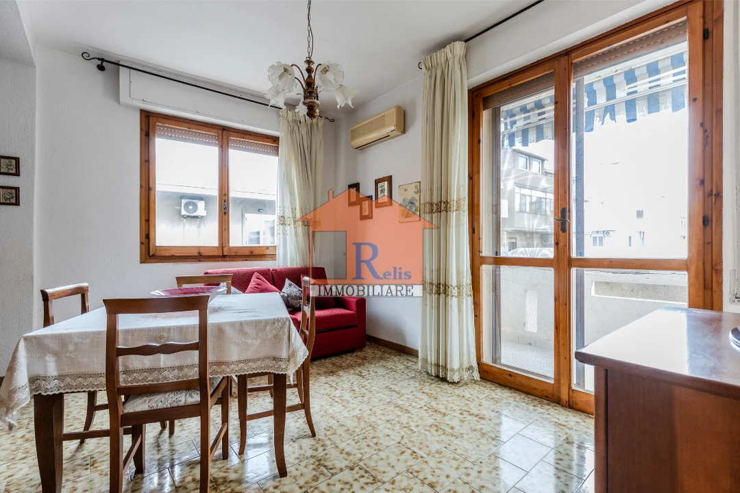 Relis Immobiliare – Luminoso quadrivano con posto auto – 7 – Soggiorno con balcone – Quartu Sant’Elena – Via Rossini Luminoso quadrivano con posto auto
