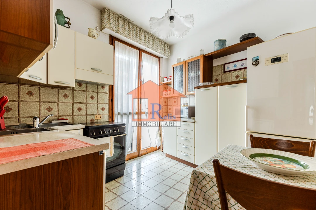 Relis Immobiliare – Luminoso quadrivano con posto auto – 9 – Cucina con balcone – Quartu Sant’Elena – Via Rossini Luminoso quadrivano con posto auto