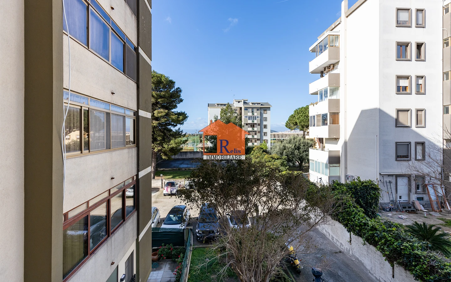 Relis Immobiliare – Quadrivano con cantina e posto auto – Vista da balcone su parcheggio condominiale – Via Bach – Quartu Sant’Elena Quadrivano con cantina e posto auto
